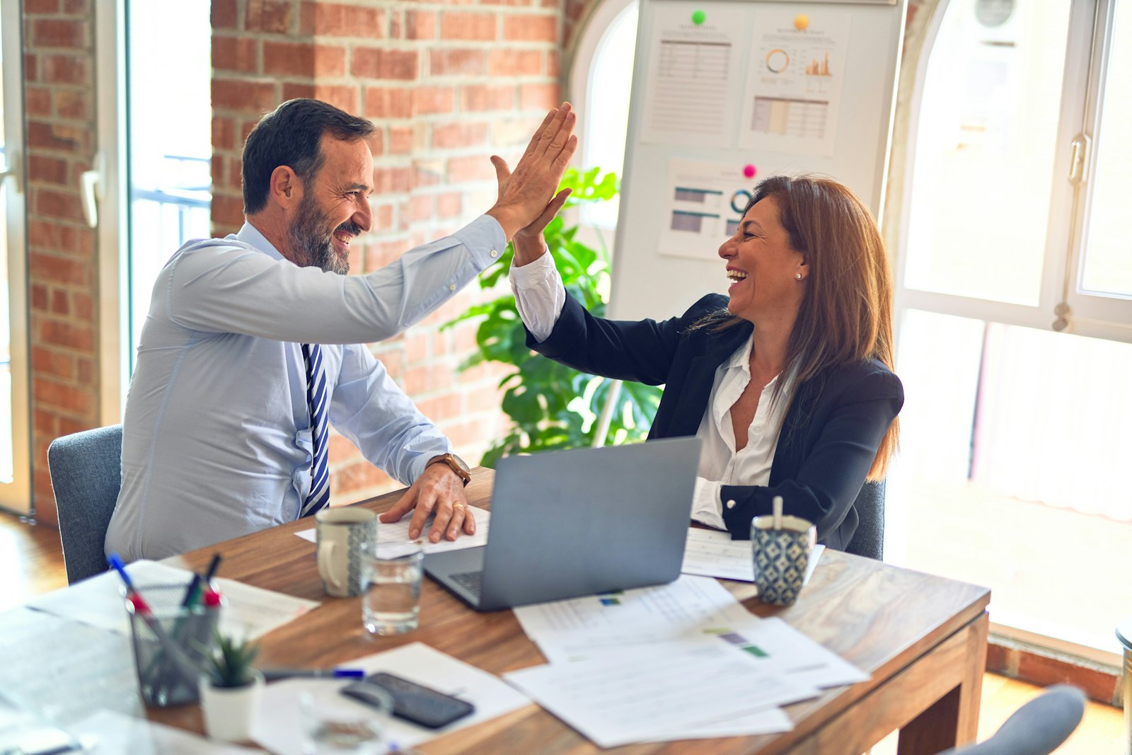 Two consultants celebrating in a meeting